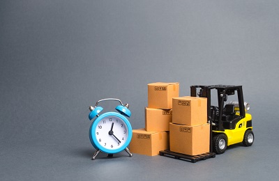 Yellow Forklift truck with cardboard boxes and a blue alarm clock.