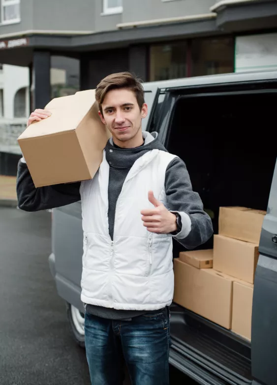 Mover carrying a cardboard box on his shoulder