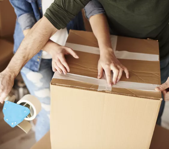 Couple taping a cardboard box