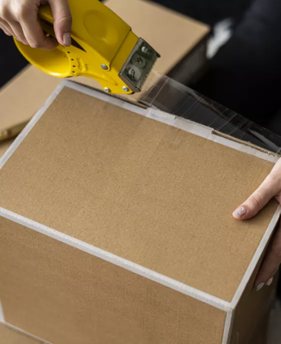 Woman taping a cardboard box